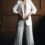 blonde girl with short blonde hair poses in white suit by the la